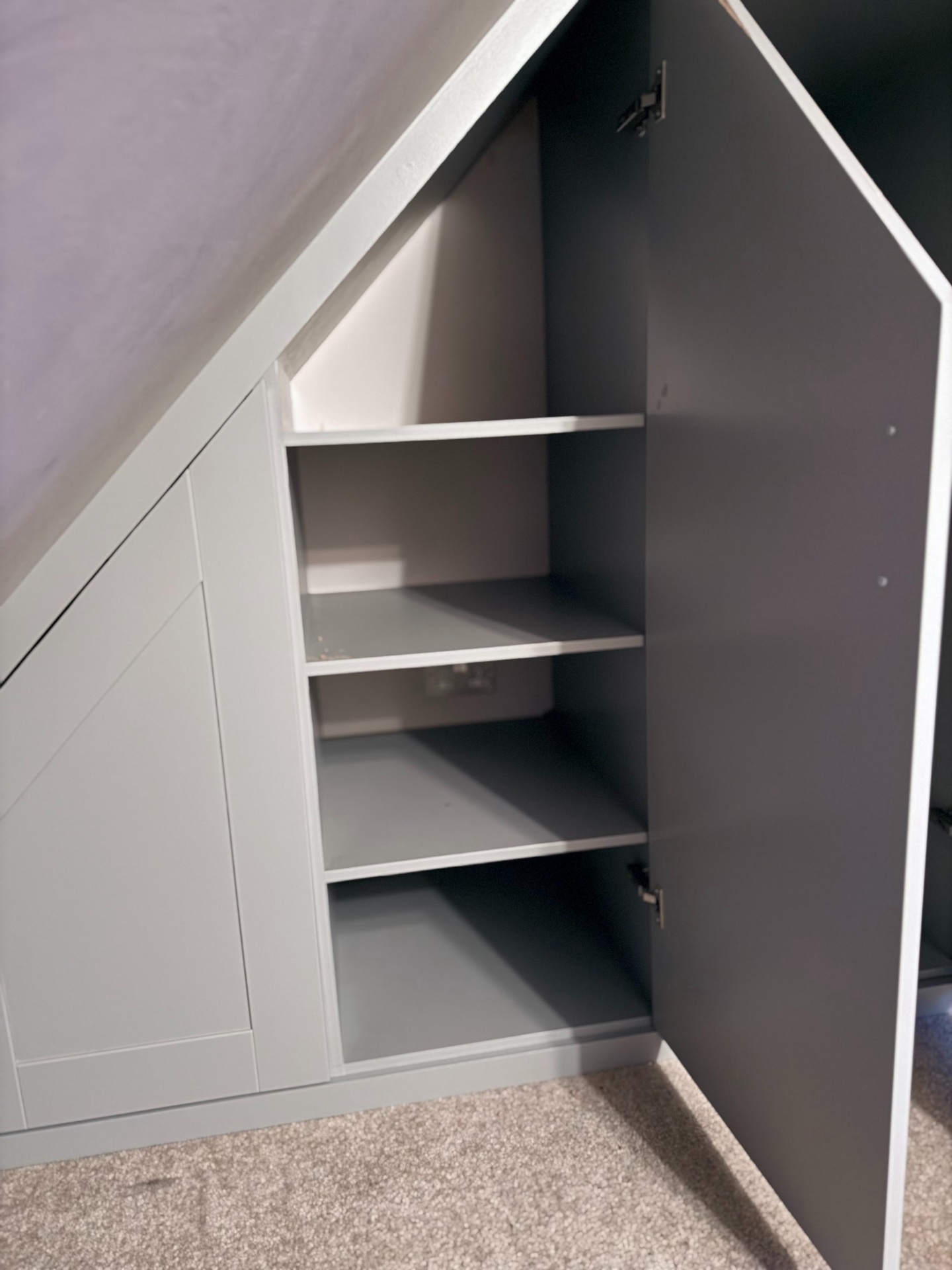 Bespoke eaves wardrobe with internal shelves and hanging space revealed