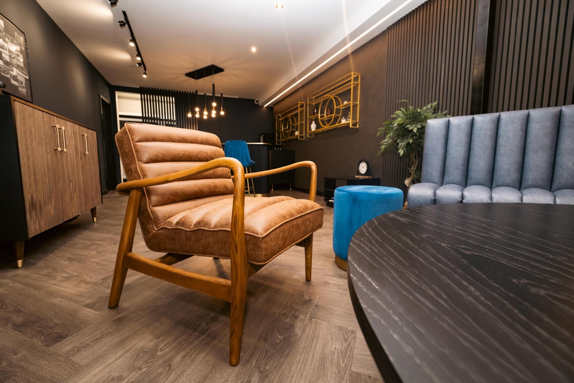 Tan leather contract lounge chair alongside a fluted banquette in a hospitality interior