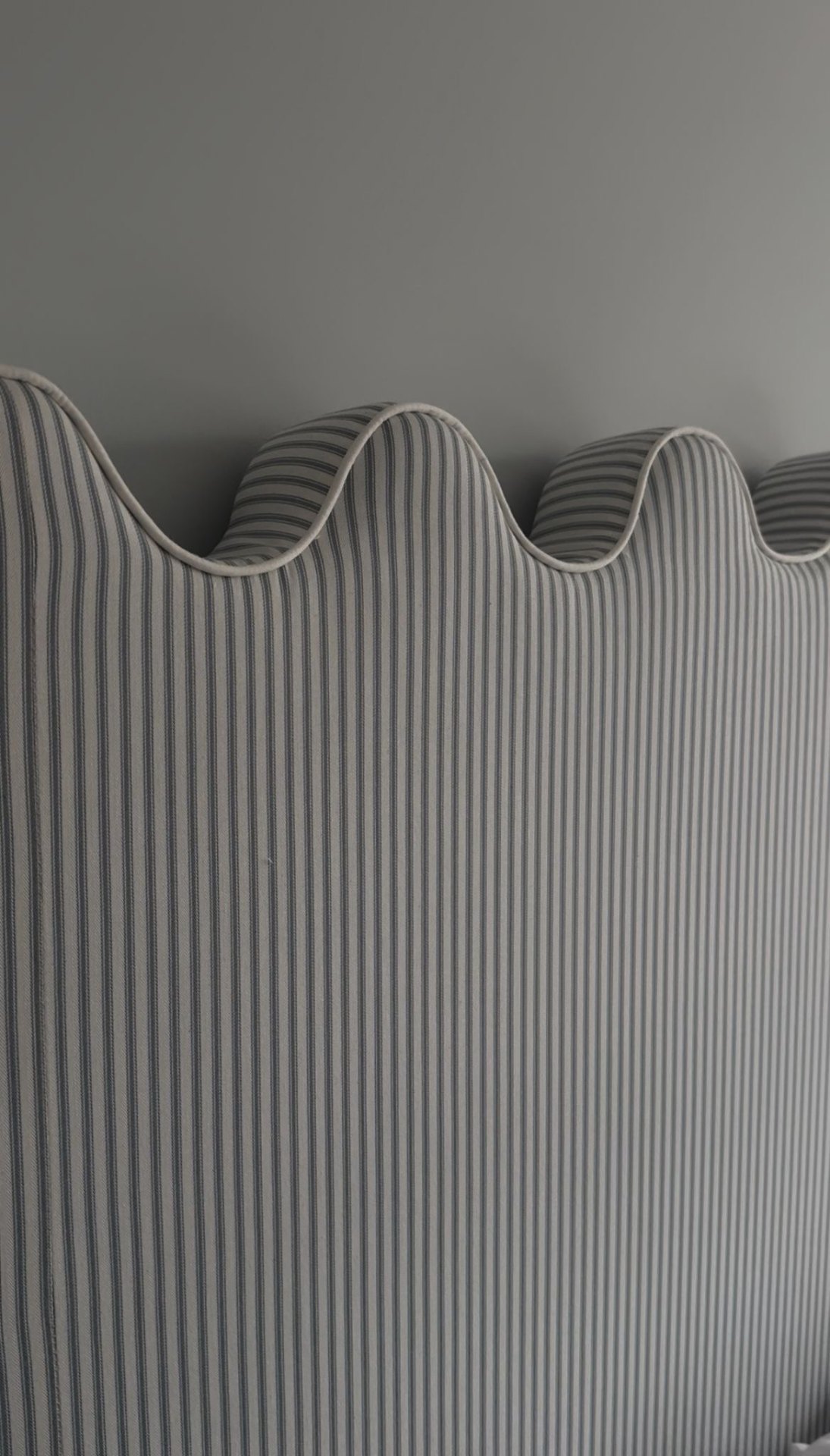 Close-up detail of a hand-finished scalloped headboard edge