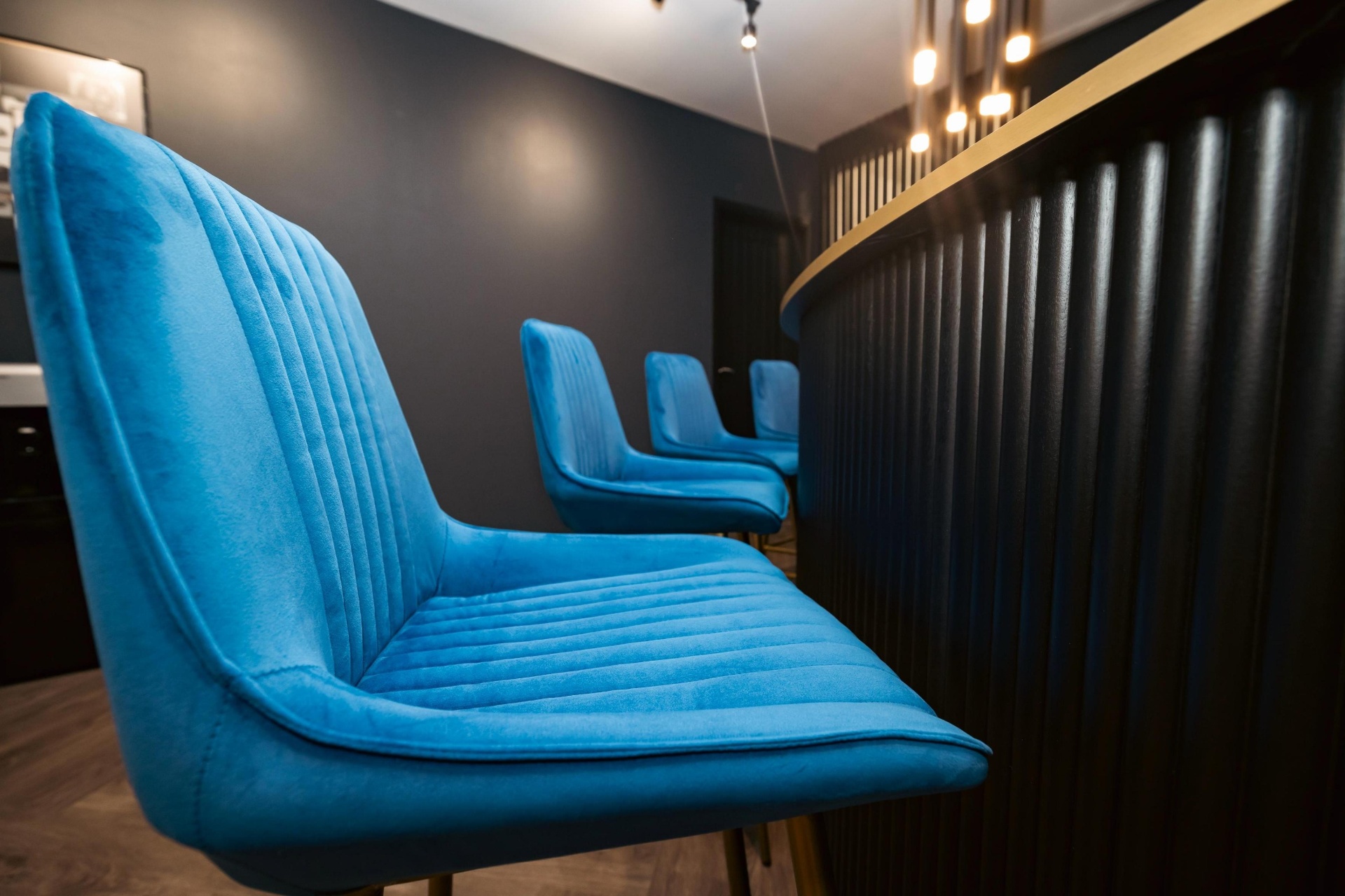 Detail of contract-grade blue velvet bar stools with fluted ribbing